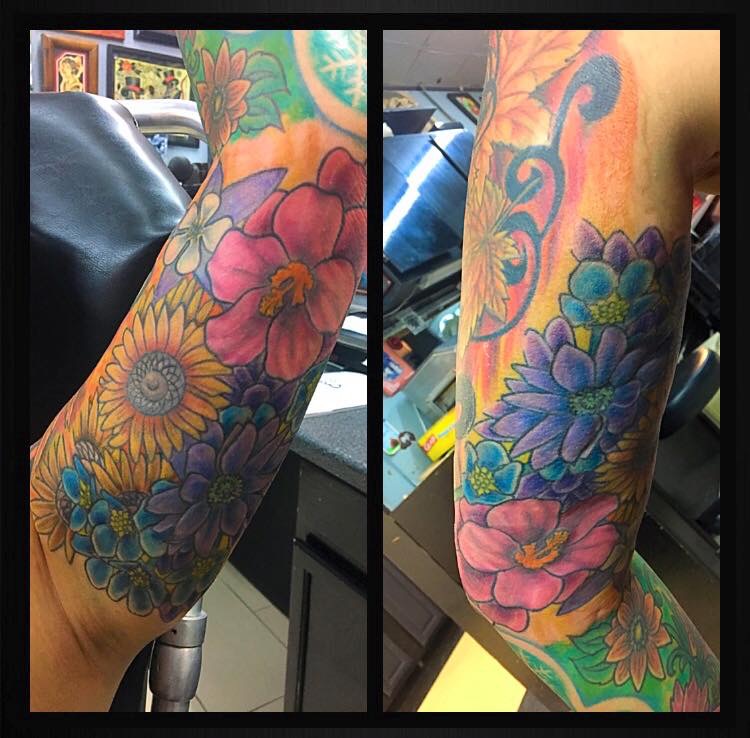 Blossoming flowers tattooed around the biceps and triceps